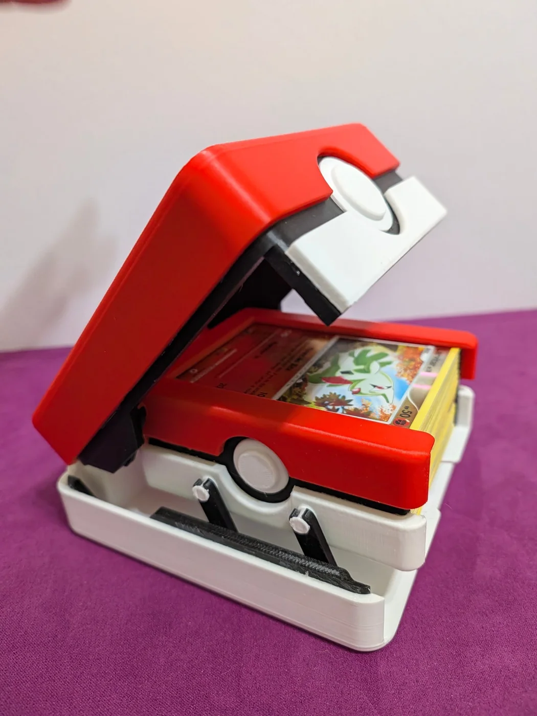 Red and white Pokémon Mechanical Deck Box partially open, with cards in the lifting tray